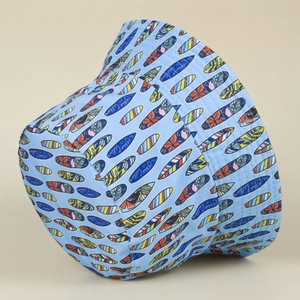 Detail of blue bucket hat featuring surfboards and The Ocean Calling print