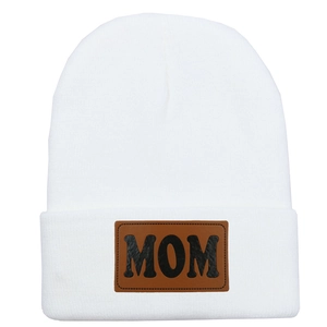 Vue détaillée du bonnet en tricot blanc avec écusson MOM en cuir brun et texture