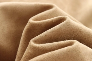 Macro view of brown faux suede fabric texture and soft pleats on a biker jacket