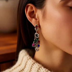Vintage gold drop earrings with multi-color gemstones and crystals on model