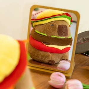 Capybara plush toy wearing a hamburger hat shown in a mirror reflection