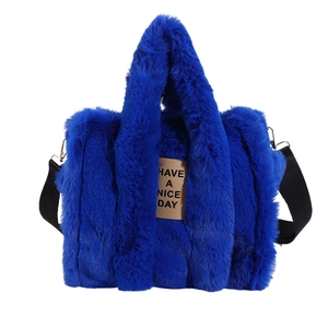Detail of plush tote bag in royal blue with 'Have a Nice Day' leather label and fuzzy texture