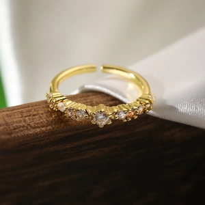 Macro detail of gold-plated adjustable ring featuring inlaid cubic zirconia stones