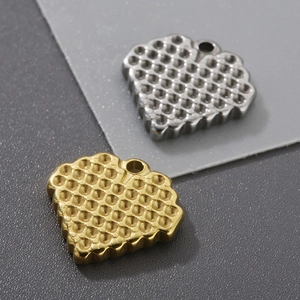 Detail of heart pendants with honeycomb texture in gold and silver finish for DIY jewelry