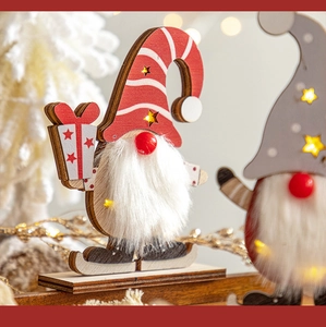 Close-up of a glowing wooden Christmas gnome with a striped hat and LED lights