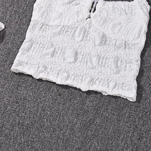 Detail of white textured crop top showing intricate lace knitting and ribbed fabric