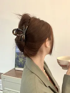 Detail of tortoise shell bow hair claw clip showing elegant updo hairstyle styling