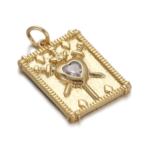 Detailed view of a gold-plated rectangular pendant with a heart gemstone and sword motifs