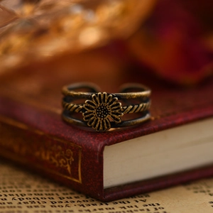 Vintage bronze sunflower open ring with triple layers on a retro book background