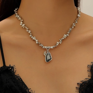 Détail de collier en perles d'argent irrégulières avec pendentif cœur gris foncé