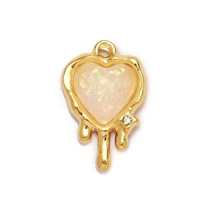 Detailed macro view of a melting gold heart pendant with pink glitter inlay and rhinestone