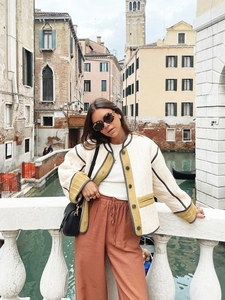 Women's cream quilted jacket with yellow trim styled in a Venetian street scene