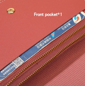 Macro detail of red lychee grain leather wallet with gold zipper and front pocket