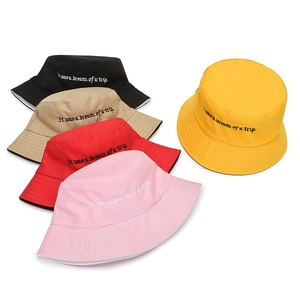 Detail of colorful reversible fisherman hats featuring retro embroidered English quotes