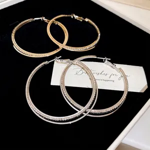 Double-layered gold and silver interlaced hoop earrings with pavé diamond accents
