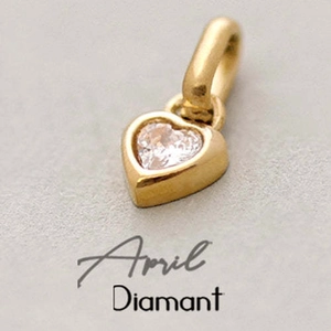 Macro detail of a heart-shaped golden pendant with an April diamond birthstone setting