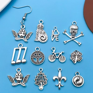 Detailed assortment of 12 Tibetan silver DIY jewelry charms on a blue background