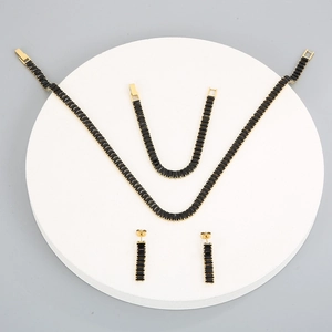 Golden jewelry set with black rectangular stones featuring a necklace, bracelet, and earrings