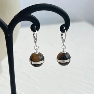 Detail of tiger eye sphere earrings with silver ring and French hooks on black stand