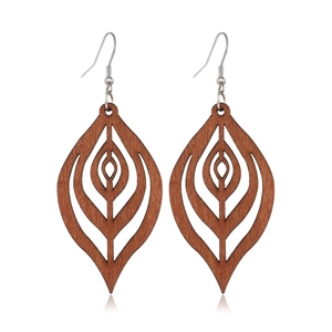 Detail of brown leaf-shaped hollowed wood earrings with silver hooks on white background