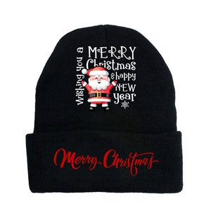 Detail of Christmas Santa print and festive lettering on black knit winter beanie
