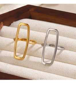 Macro shot of minimalist gold and silver rectangular rings on a soft textile jewelry box