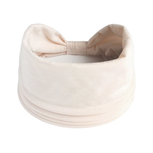 Dettaglio fascia per capelli yoga color crema in maglia morbida con decorazione a fiocco