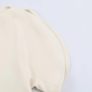 Detail of puff short sleeve design on beige woven top with sharp fabric texture