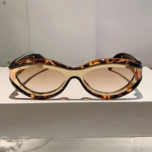 Detail of tortoiseshell frame cat eye sunglasses with gold metallic accents and tinted lenses