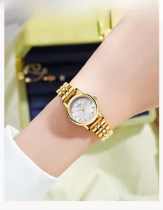 Primer plano de un reloj vintage para mujer con correa dorada y esfera de nácar en la muñeca