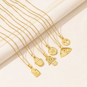 Detail of golden stainless steel necklaces with evil eye and hand of fatima pendants