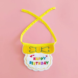 Detailed view of yellow knitted pet birthday bib with Happy Birthday white embroidery