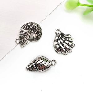 Detailed close-up of antique silver sea shell pendants for DIY jewelry making