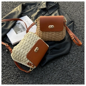 Close-up of handmade straw and PU leather crossbody bag with golden metal twist lock detail