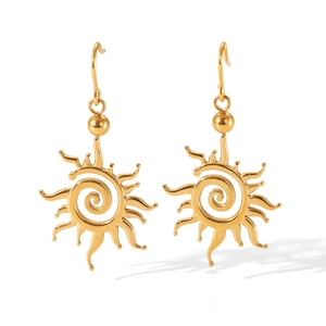 Vue détaillée de boucles d'oreilles soleil dorées avec motif en spirale et rayons radiaux