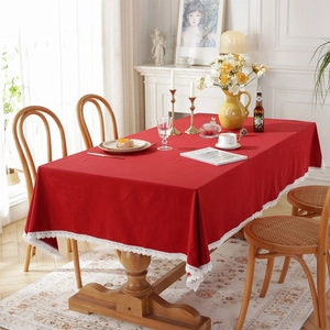 French vintage red cotton tablecloth with elegant white lace borders on a wooden table