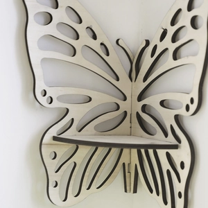 Close-up of a butterfly-shaped wooden corner shelf with detailed hollowed-out carving