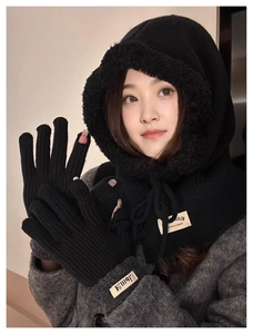 Detail of black knitted balaclava with matching fingerless gloves for winter warmth