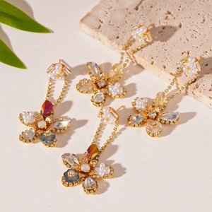 Elegant zircon flower earrings with pearls and crystals on textured stone background