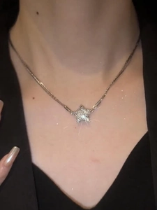Close-up of magnetic sparkling star pendant necklace with crystals on model's neck