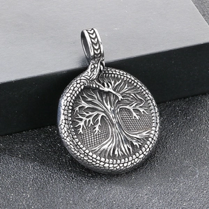 Detail of vintage stainless steel Jormungandr Ouroboros pendant with Tree of Life symbol