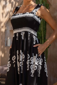 Detail of smocked chest area and ruffle straps on a black floral vacation midi dress