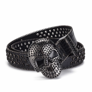 Macro shot of black skull buckle with rhinestones and rivet stud crocodile leather belt