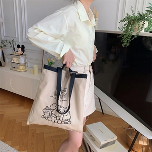 Woman carrying a beige canvas tote bag featuring lucky cartoon animal print for daily use