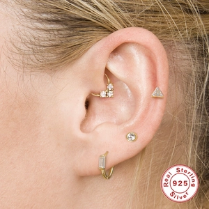 Detailopname van 925 sterling zilveren gouden oorpiercings met glinsterende zirkonia's