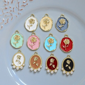 Macro shot of assorted enamel rose pendants with pearls on a light blue tray