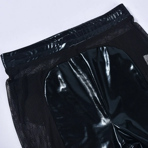 Detail of black faux leather and sheer mesh stitching on high-waist textured leggings