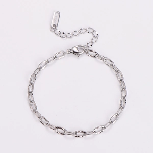 Macro view of silver embossed stainless steel chain bracelet with 18KGP tag and lobster clasp