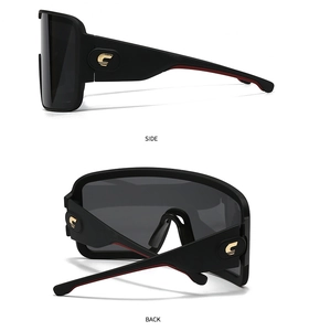 Macro view of matte black oversized sunglasses with gold C logo and red temple accents