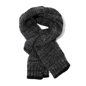 Detail of grey mixed-knit scarf showing thick wool texture and black ribbed hem edges